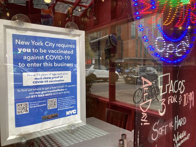 The sign outside a restaurant informing visitors they must be vaccinated to enter the business.